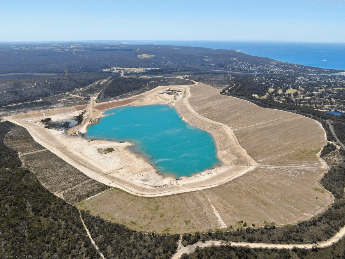 Aerial view over a former mine pit, showing grasslands and topsoil revegetation establishment